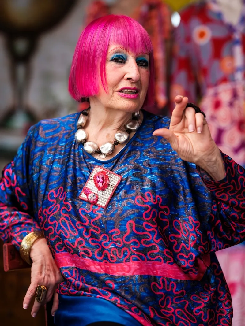 Dame Zandra Rhodes crosses her fingers like the National Lottery logo