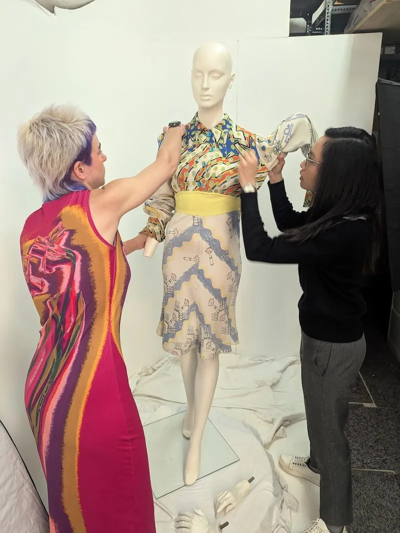Interns Emily Ash and Angela Kusuma prepare clothing on a mannequin ready for it to be photographed for the digital archive