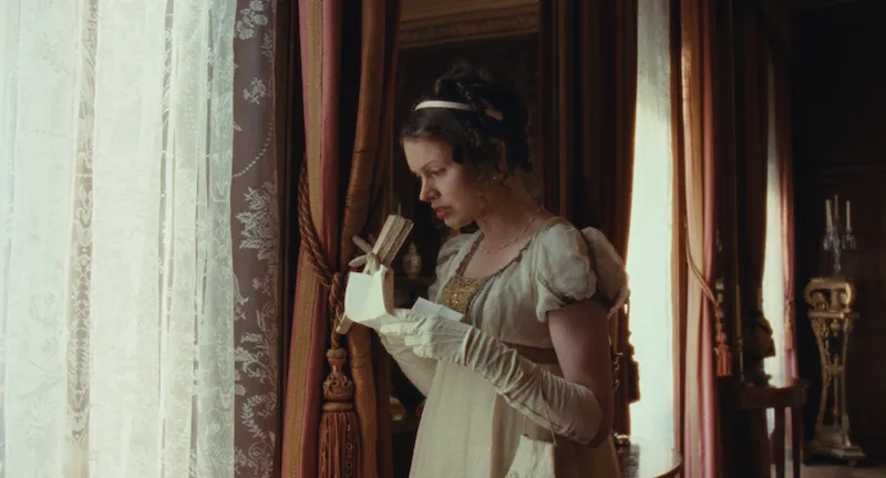 A still from the short film Tommies. Georgina (Sarah Winter) reads a letter by a window