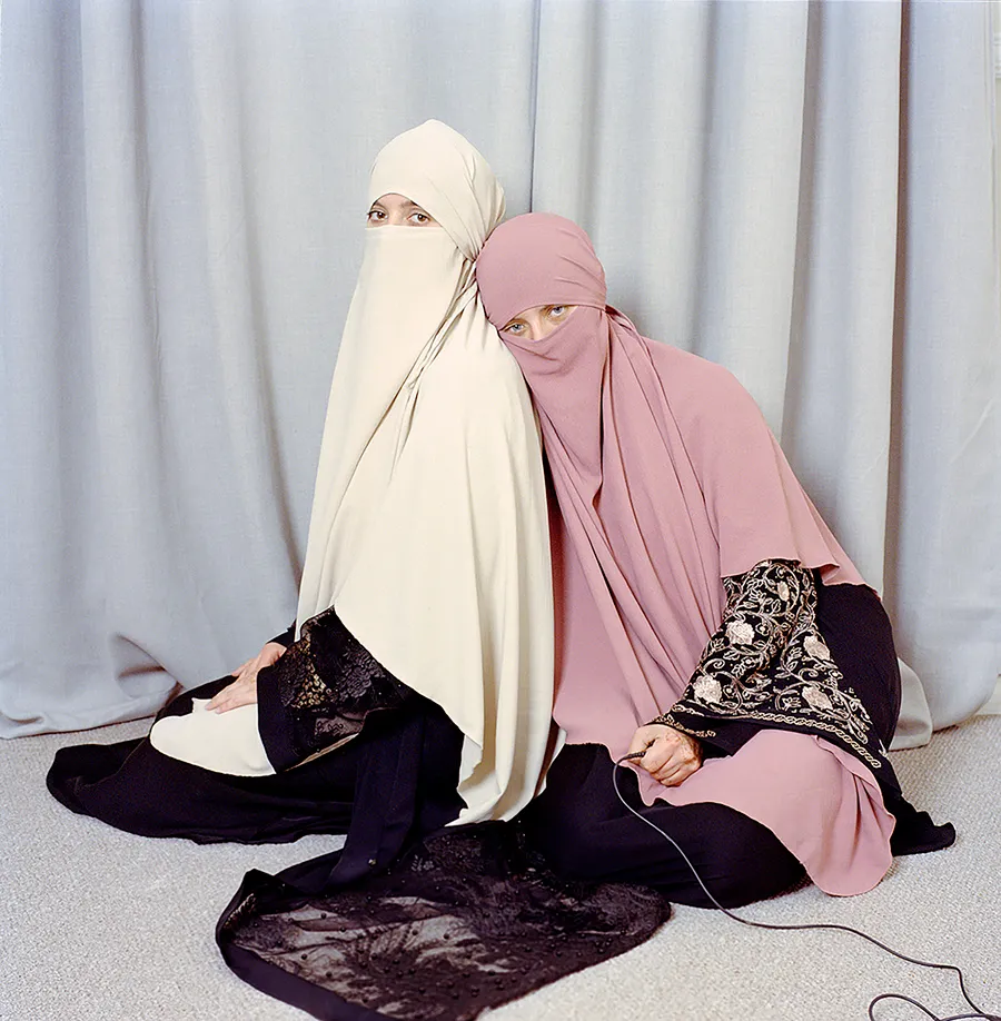 Jodie Bateman and sister Hannah wear hijabs against a grey background