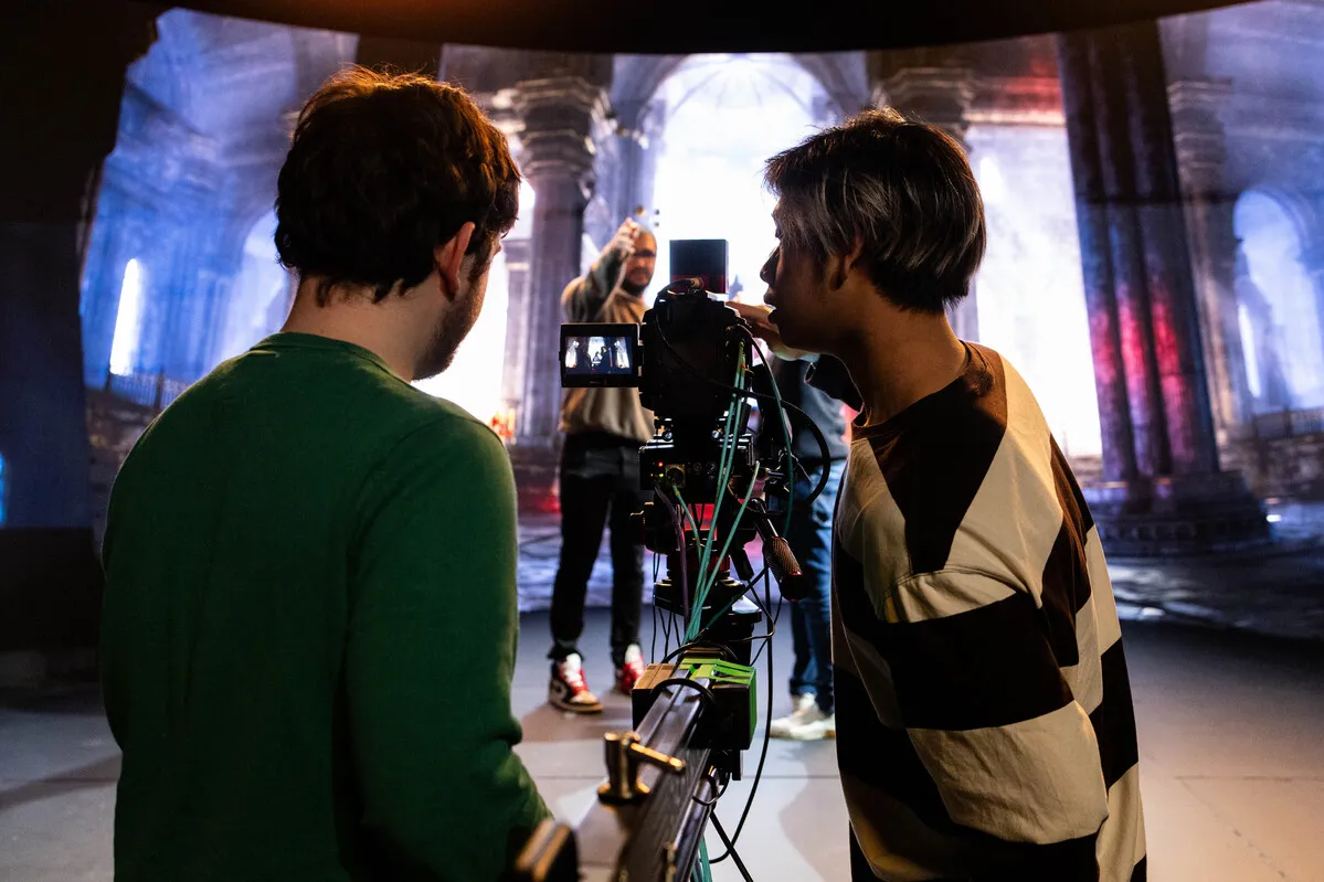 Two people operating a camera in the virtual production studio