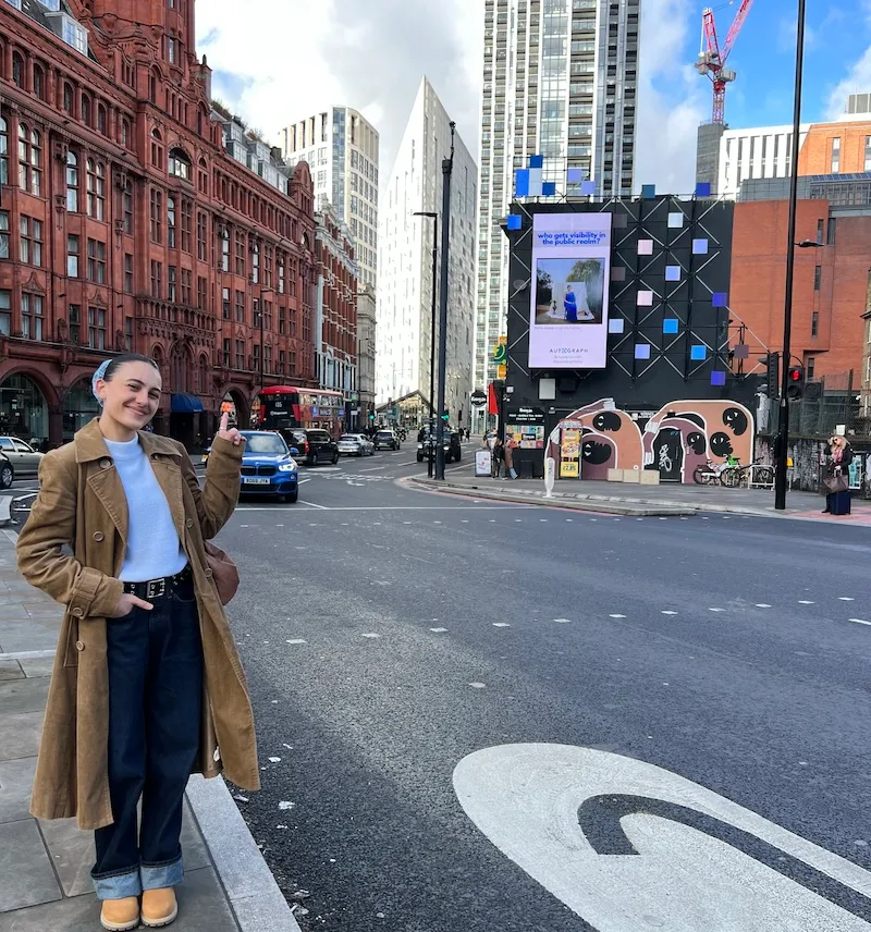 Olivia Cooper standing in fron of the billboad at Old Street