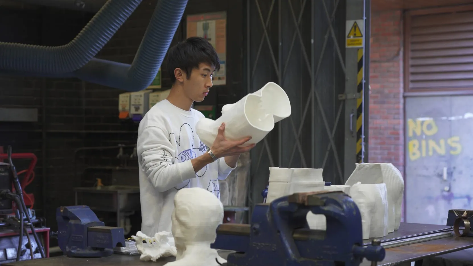 Kota Ishida holding a sculpture in a UCA workshop