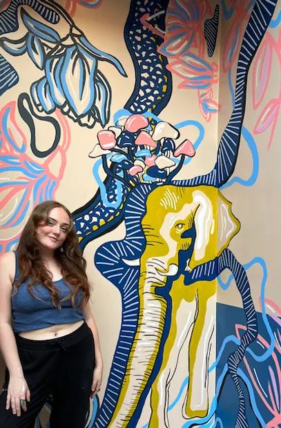 An image of Bri Chartrand in front of her work