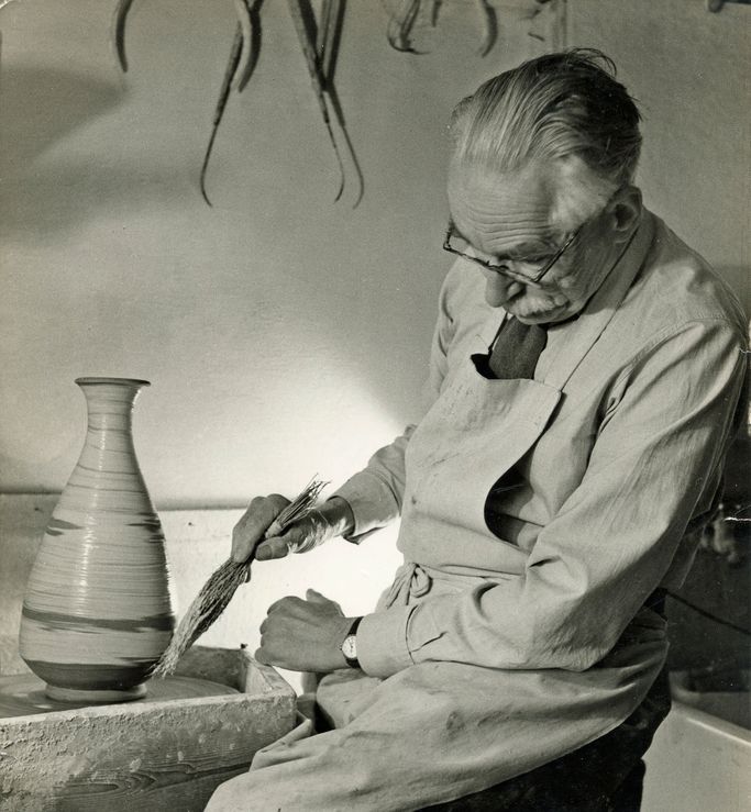 Bernard Leach working at the wheel and applying decoration to a stoneware pot  with a hakeme (twig) brush at St Ives, 1963. From the Bernard Leach archive at the Crafts Study Centre, BHL/7095.