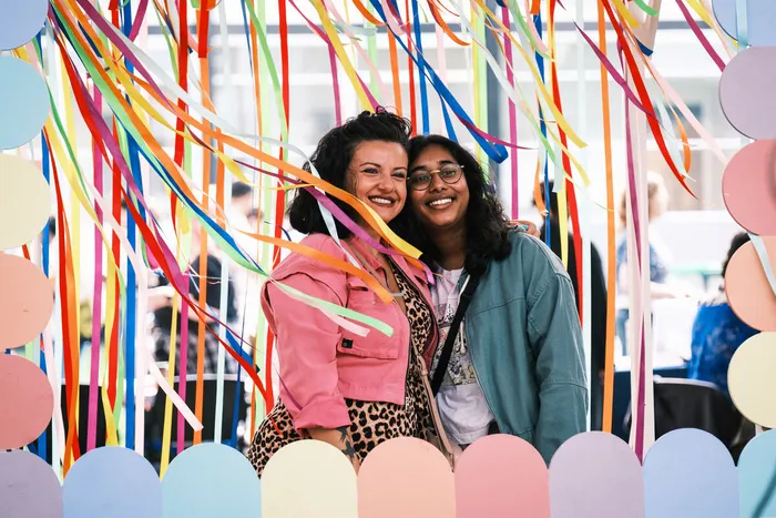 Students posing for a photo with some colourful streamers at the Freshers