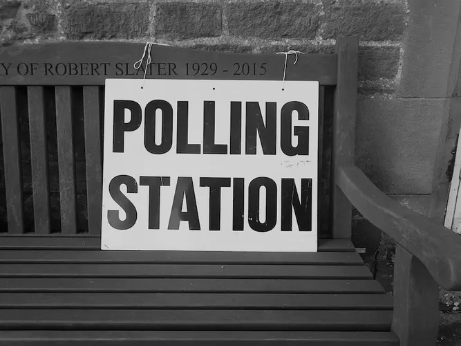 An image of a Polling Station sign on a bench