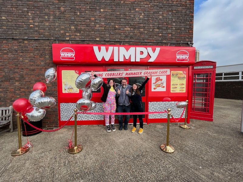 Sally King and colleagues in front of a Wimpy set