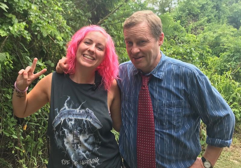 UCA graduate Sally King, in a vest with pink hair, is stood with actor Ardal O'Hanlon