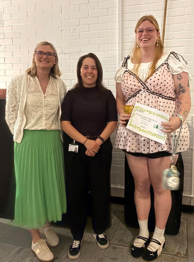 Caroline Wright and Verity Lavender from Forestry England present Sam Watson with the Forestry England Prize for Art Director
